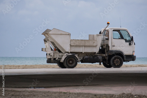 small beach maintenance truck performing cleaning tasks