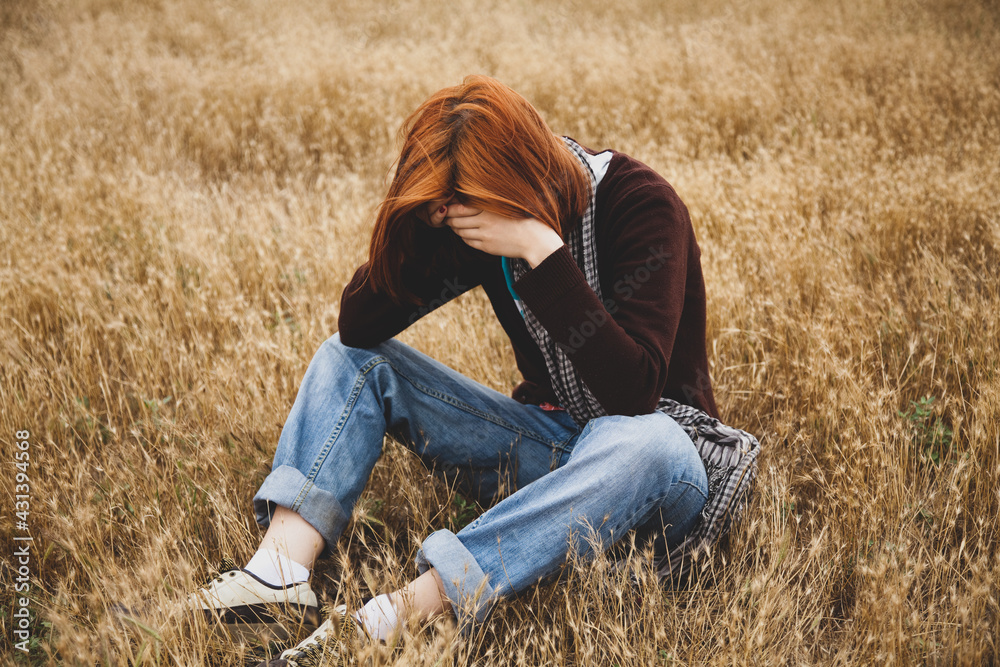 Lonely sad red-haired girl at field Lonely sad red-haired girl at field