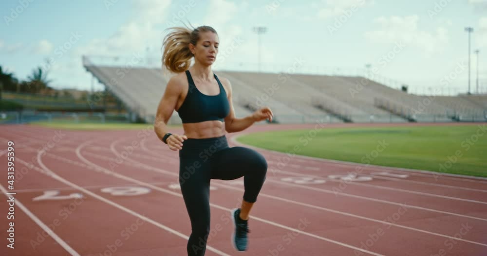 Attractive young woman warming up at the track for a workout, athletic and strong, confident athlete, active lifestyle Attractive young woman warming up at the track for a workout, athletic and strong, confident athlete, active lifestyle