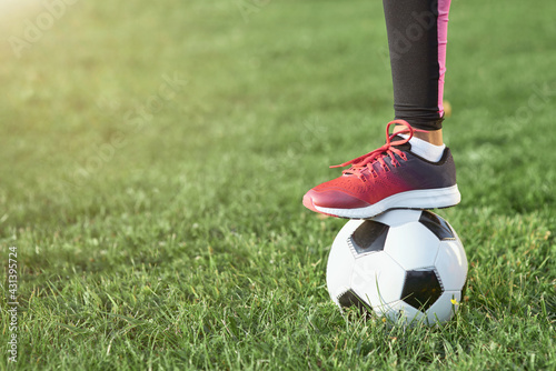 Female child with soccer ball standing on grass