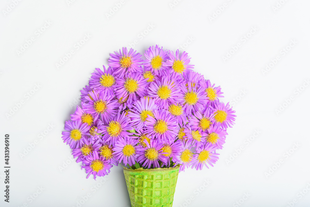Waffle cone with flowers on white background. Flat lay, top view.