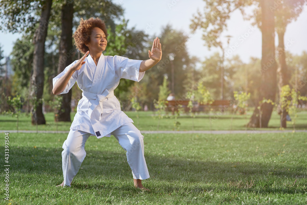 Cute little girl practicing martial arts on sunny day in park Cute little girl practicing martial arts on sunny day in park