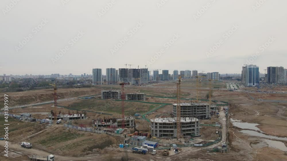 Flight over the construction site. High-rise buildings under construction and construction cranes are visible. Aerial photography. Flight over the construction site. High-rise buildings under construction and construction cranes are visible. Aerial photography.