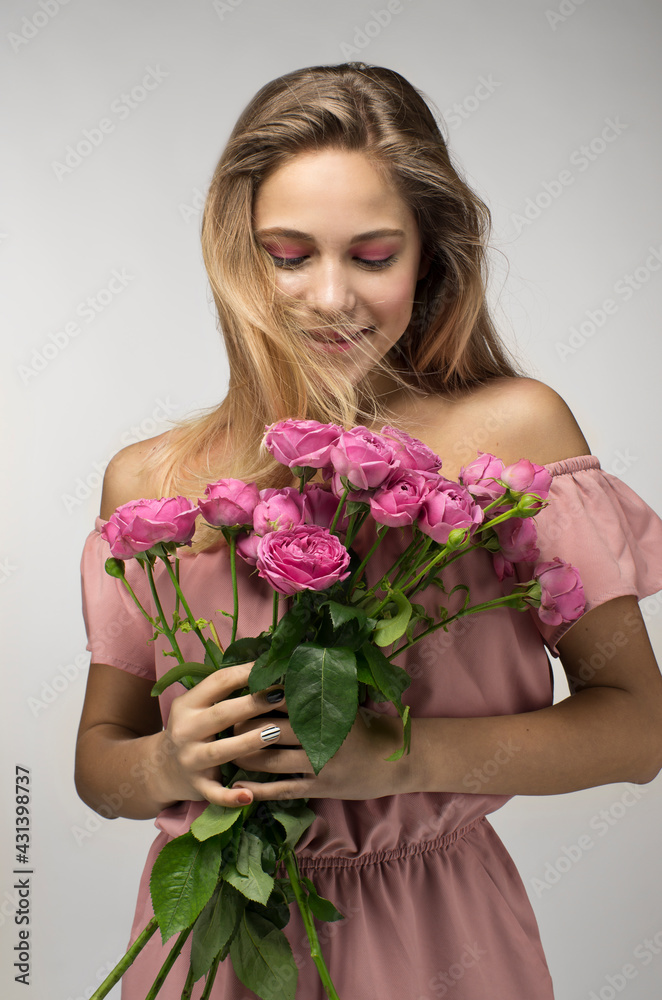 Blonde girl with a bouquet of roses flowers isolated on a gray background, Romantic Valentine's Day girl Blonde girl with a bouquet of roses flowers isolated on a gray background, Romantic Valentine's Day girl