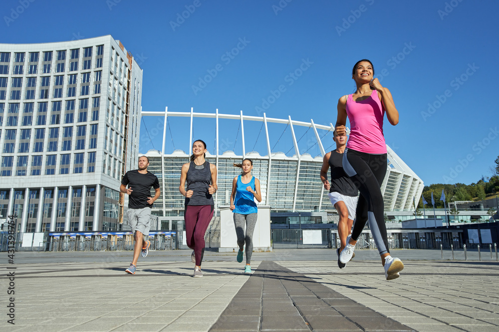Fototapeta premium Happy young mixed racial team running during training