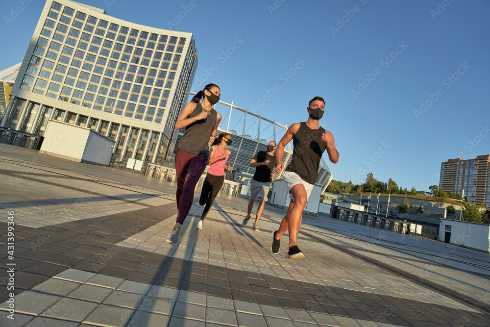 Obraz premium Young mixed race athletes in protective masks running