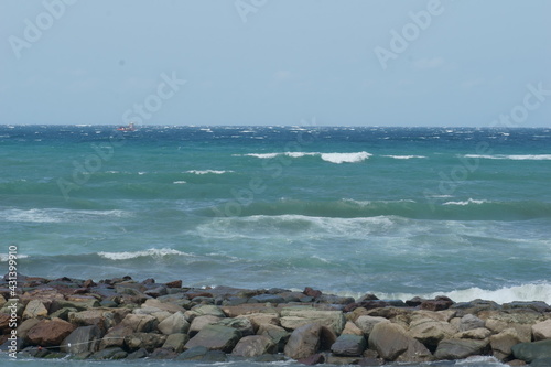 View of rough sea near rocky pier
