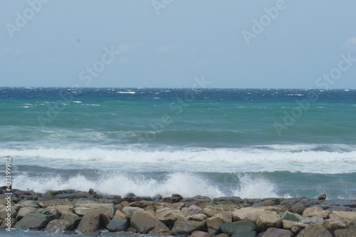 View of rough sea near rocky pier
