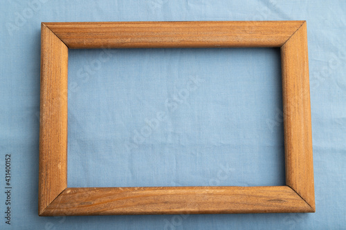 Wooden frame on smooth cotton blue tissue. Top view  natural textile background.