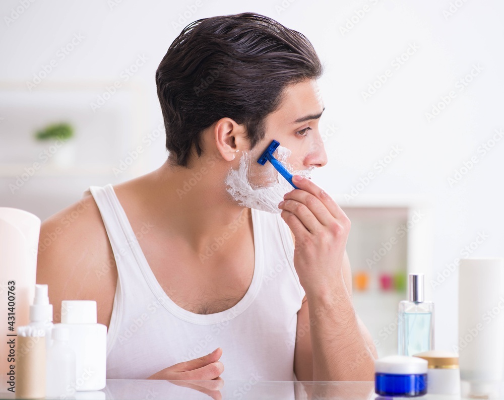 Young handsome man shaving early in the morning at home Young handsome man shaving early in the morning at home