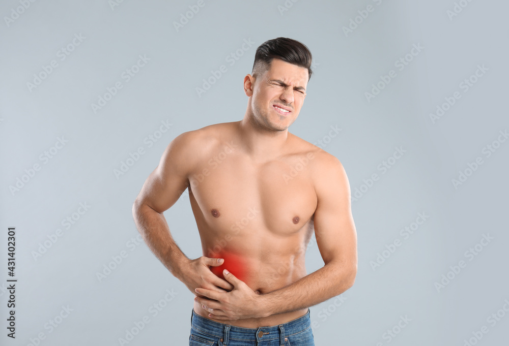 Man suffering from liver pain on grey background