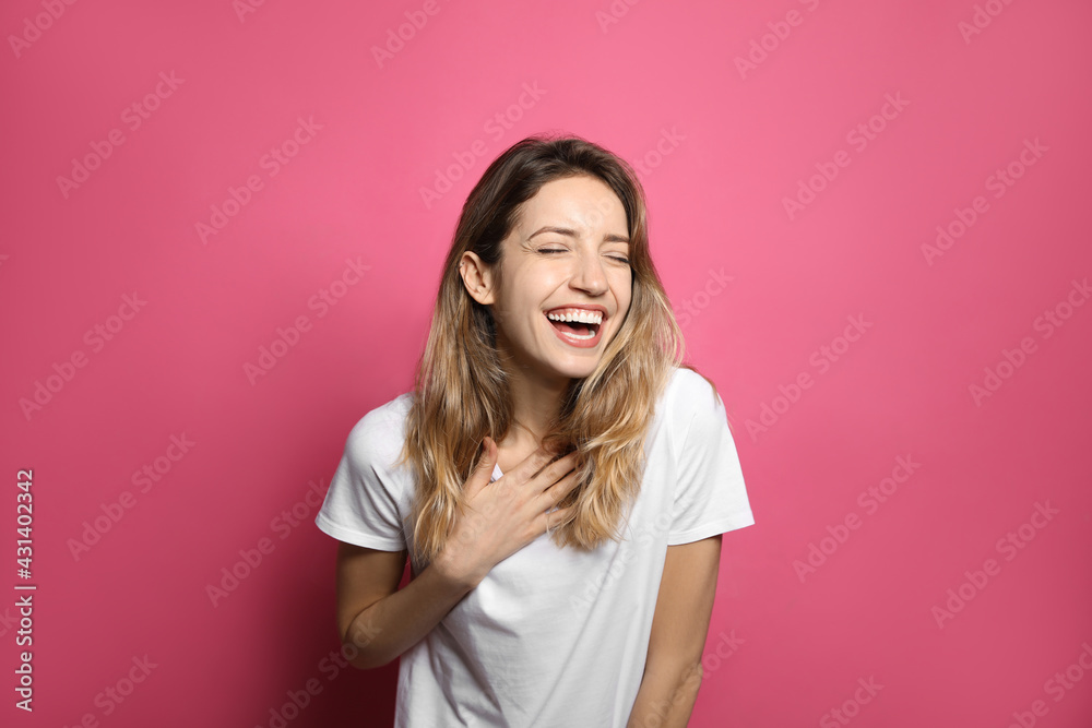 Cheerful young woman laughing on pink background Cheerful young woman laughing on pink background