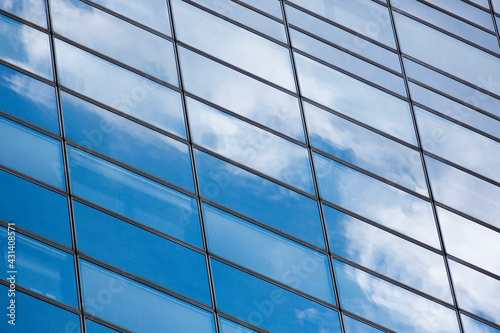 Modern skyscraper blue windows glass wall with reflections.