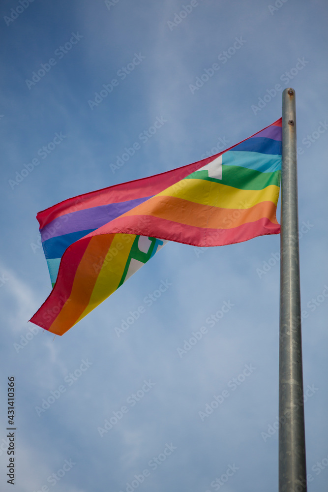 flag in rainbow colors flying against a clear blue sky in sunny weather flag in rainbow colors flying against a clear blue sky in sunny weather
