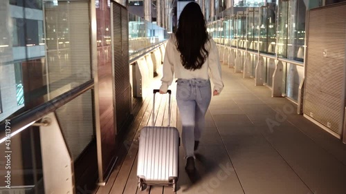 ガラス張りの歩道橋を歩く女性 photo