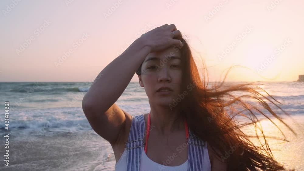 サンセットの中髪をかきあげる女性 サンセットの中髪をかきあげる女性