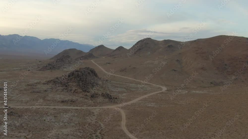 Aerial Panning Shot Of Dirt Road At Famous Alabama Hills Against Sky, Drone Flying Forward Over Rocky Landscape At Sunset - Sierra, California Aerial Panning Shot Of Dirt Road At Famous Alabama Hills Against Sky, Drone Flying Forward Over Rocky Landscape At Sunset - Sierra, California