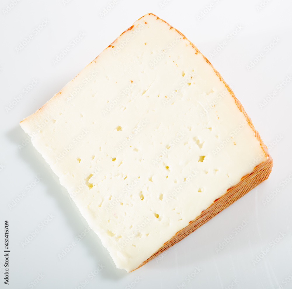 Cut piece of fresh cow cheese on wooden background