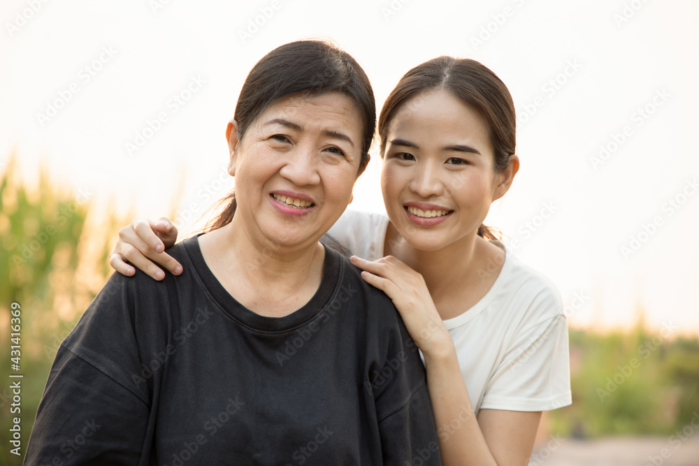 Senior mother staying in the park with asian young adult daughter, healthy lifestyle, family togetherness, mother and daughter, mother day concept Senior mother staying in the park with asian young adult daughter, healthy lifestyle, family togetherness, mother and daughter, mother day concept