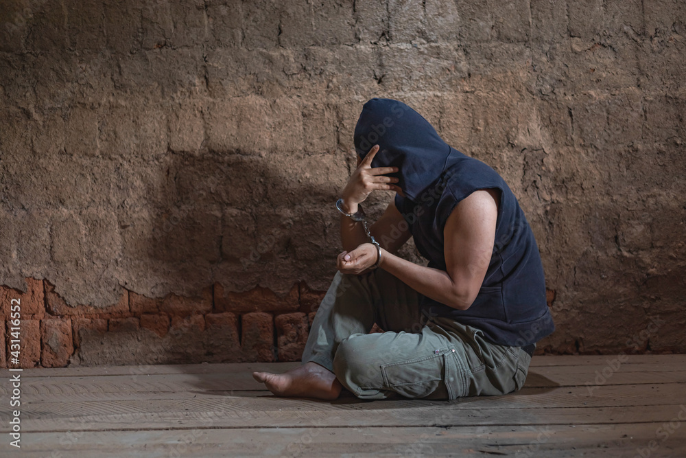 Fototapeta premium prisoner concept,Handcuffed hand of a prisoner in prison, Male prisoners were severely strained in the dark prison, violence,