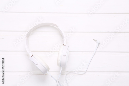 Stereo headphones on white wooden background. Top view