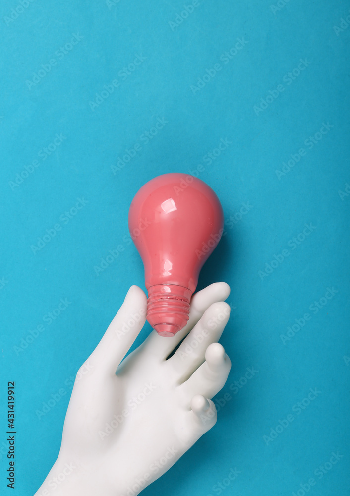 Hand holding Pink light bulb on blue background. Minimalism. Creative layout. Fresh idea. - obrazy, fototapety, plakaty 