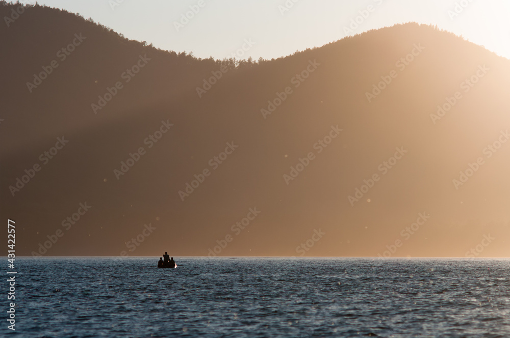people on the boat trip. fishers at the sunset