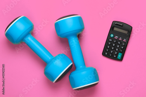Fitness, sport concept. Calorie Counting. Calculator and dumbbell on pink background. Top view