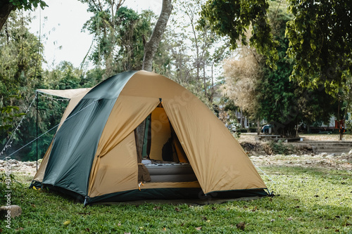 Camping picnic green tent campground in outdoor hiking forest. Camper while campsite in nature background at summer trip camp. Adventure Travel Vacation concept