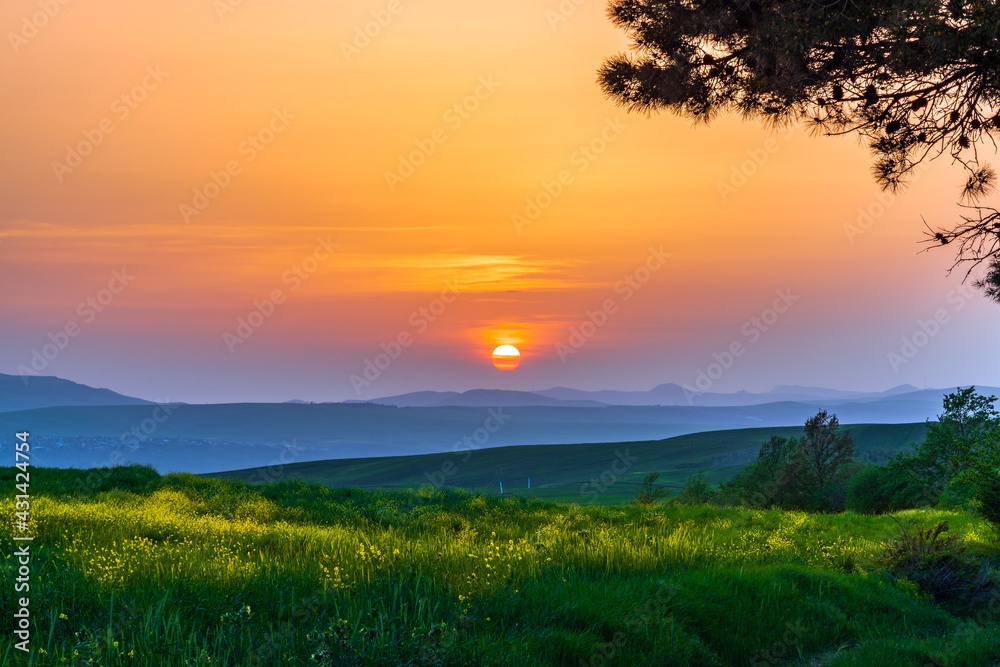Colorful sunset over green fields