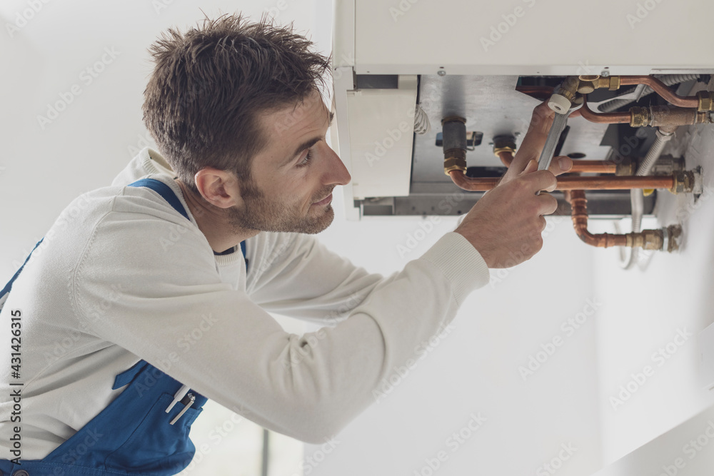 Professional plumber checking a boiler Professional plumber checking a boiler