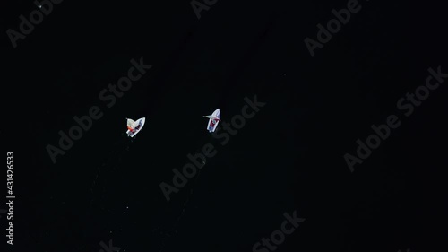 Aerial downward view of two small sailboats racing slowly with passing seagull photo