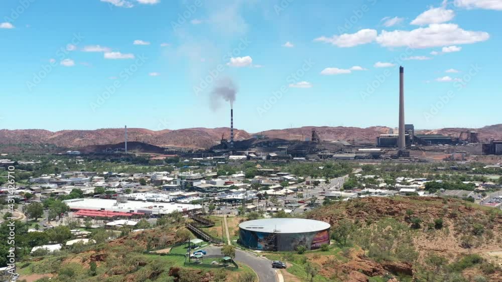 2020 - Excellent aerial shot of traffic near the smokestacks of an industrial center in Mount Isa, Australia.