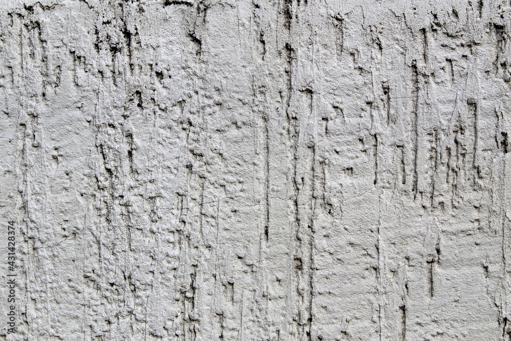 Gray concrete wall with uneven rough plaster