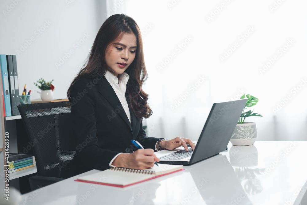 Business women working with laptop and take note Business women working with laptop and take note