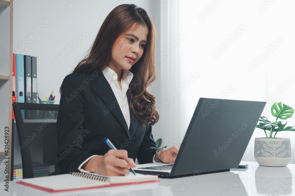 Business women working with laptop and take note Business women working with laptop and take note