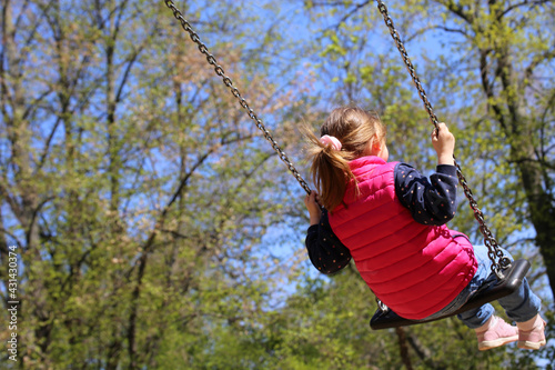 Mädchen schaukelt auf einem Spielplatz (model released)