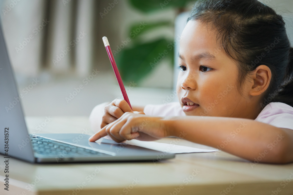 Asian child girl student study online with teacher by video call. Child is homeschooling with computer laptop during quarantine due to Covid 19 pandemic. Asian child girl student study online with teacher by video call. Child is homeschooling with computer laptop during quarantine due to Covid 19 pandemic.