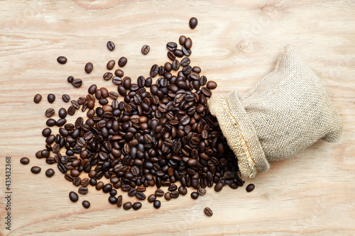 Black roasted coffee beans in a small burlap.