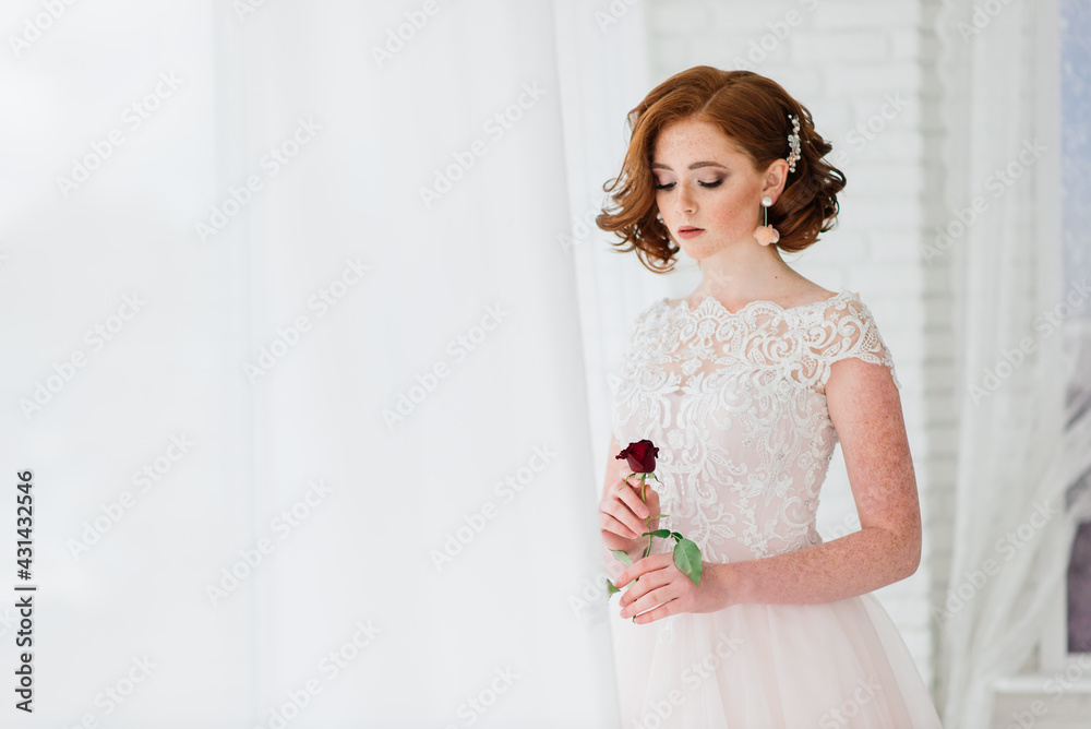 Portrait of red haired girl wearing wedding dress against a white studio background. Portrait of red haired girl wearing wedding dress against a white studio background.