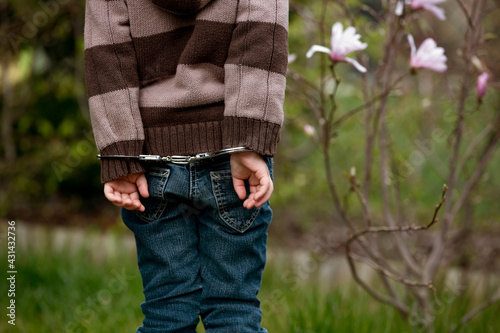 Принти на полотні Child, boy in handcuffs, standing backwards in garden