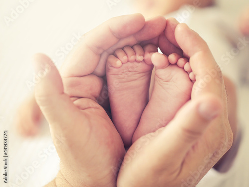 Selective focus close up a feet of newborn baby in parent 's hand , Parental care and happy family concept