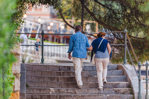 Opatija, Croatia - June 4, 2019: senior couple walking by city quay photo