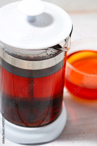 fresh black tea in French press on white backgroundtop view closeup photo