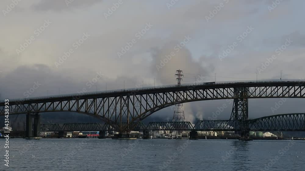 Vancouver bridge with cars passing by and seagulls in the water on a cloudy day Vancouver bridge with cars passing by and seagulls in the water on a cloudy day