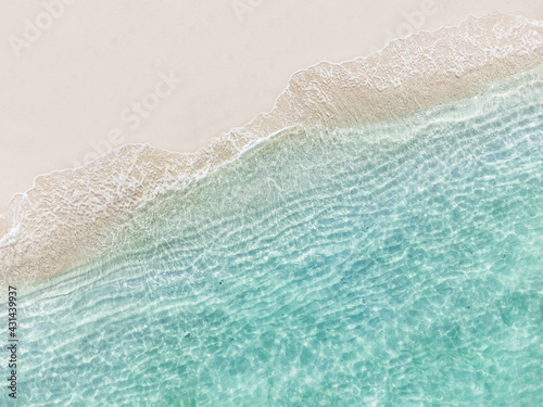Aerial top view of beautiful tropical white sand beach with wave foam and transparent sea, Summer vacation and Travel background with copy space, Top view from drone photo