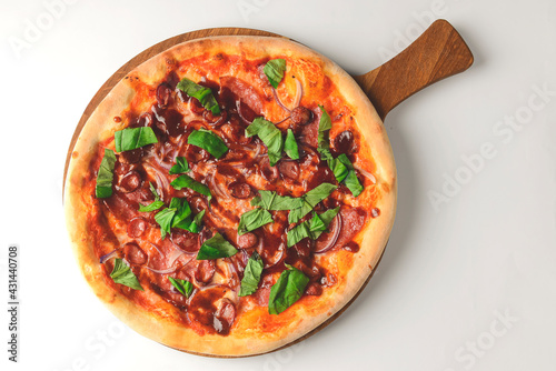 Fresh tasty pizza on white background. Traditional Italian pizza with grilled sausages and arugula over white.