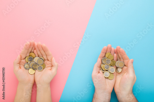 Opened young adult man and woman palms with euro coins on light blue pink table background. Pastel color. Point of view shot. Closeup. Compare income between husband and wife. Top down view.