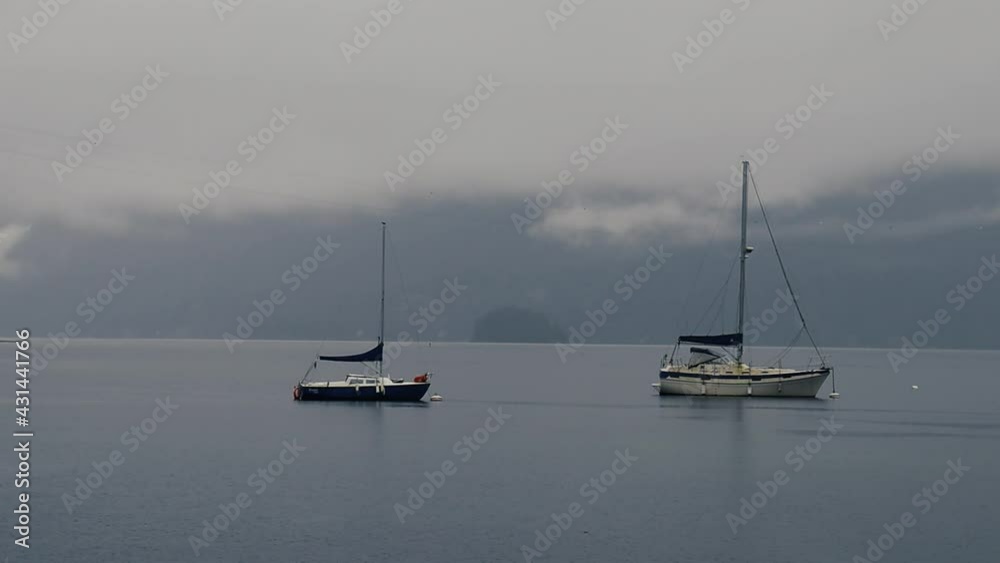 Anchored yachts on a rainy morning with cloudy mountains behind Anchored yachts on a rainy morning with cloudy mountains behind
