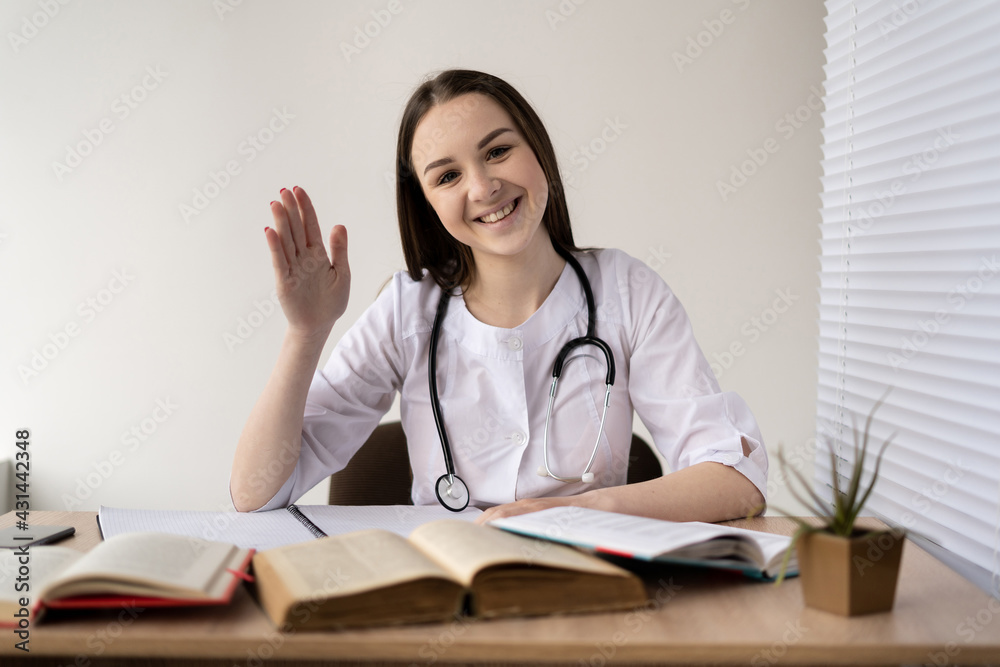 Friendly doctor or therapist in the surgery room chatting with the patient, as seen via webcam, online medical consultation. Friendly doctor or therapist in the surgery room chatting with the patient, as seen via webcam, online medical consultation.